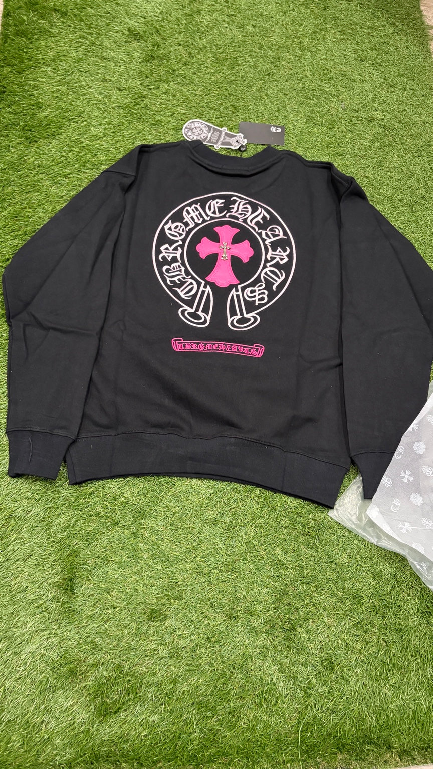 Black crewneck back with large pink cross and horseshoe emblem