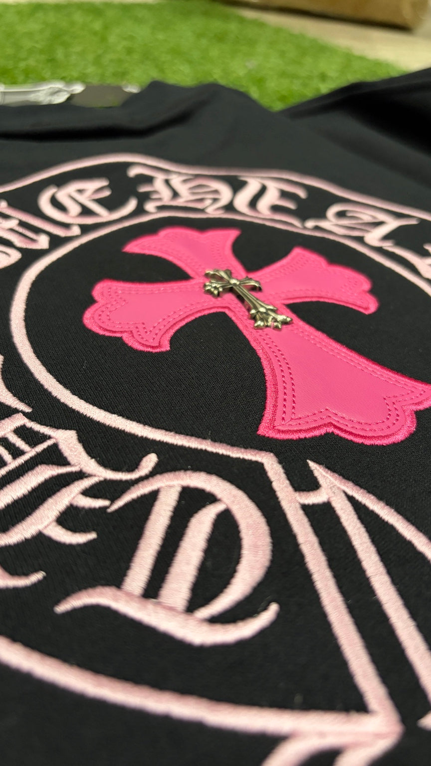 Pink cross applique and metal cross detail on back