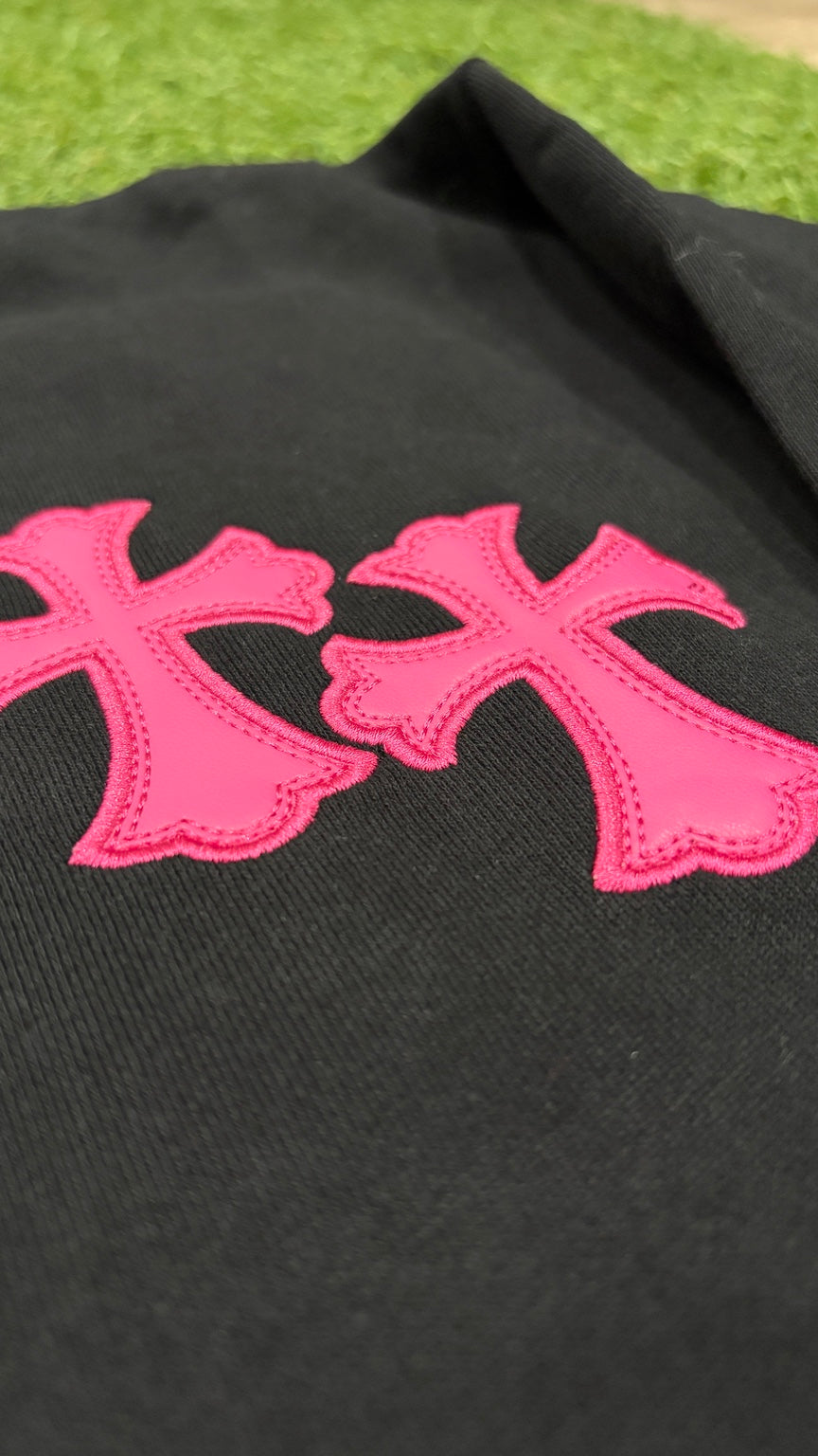 Close-up pink embroidered double crosses on front