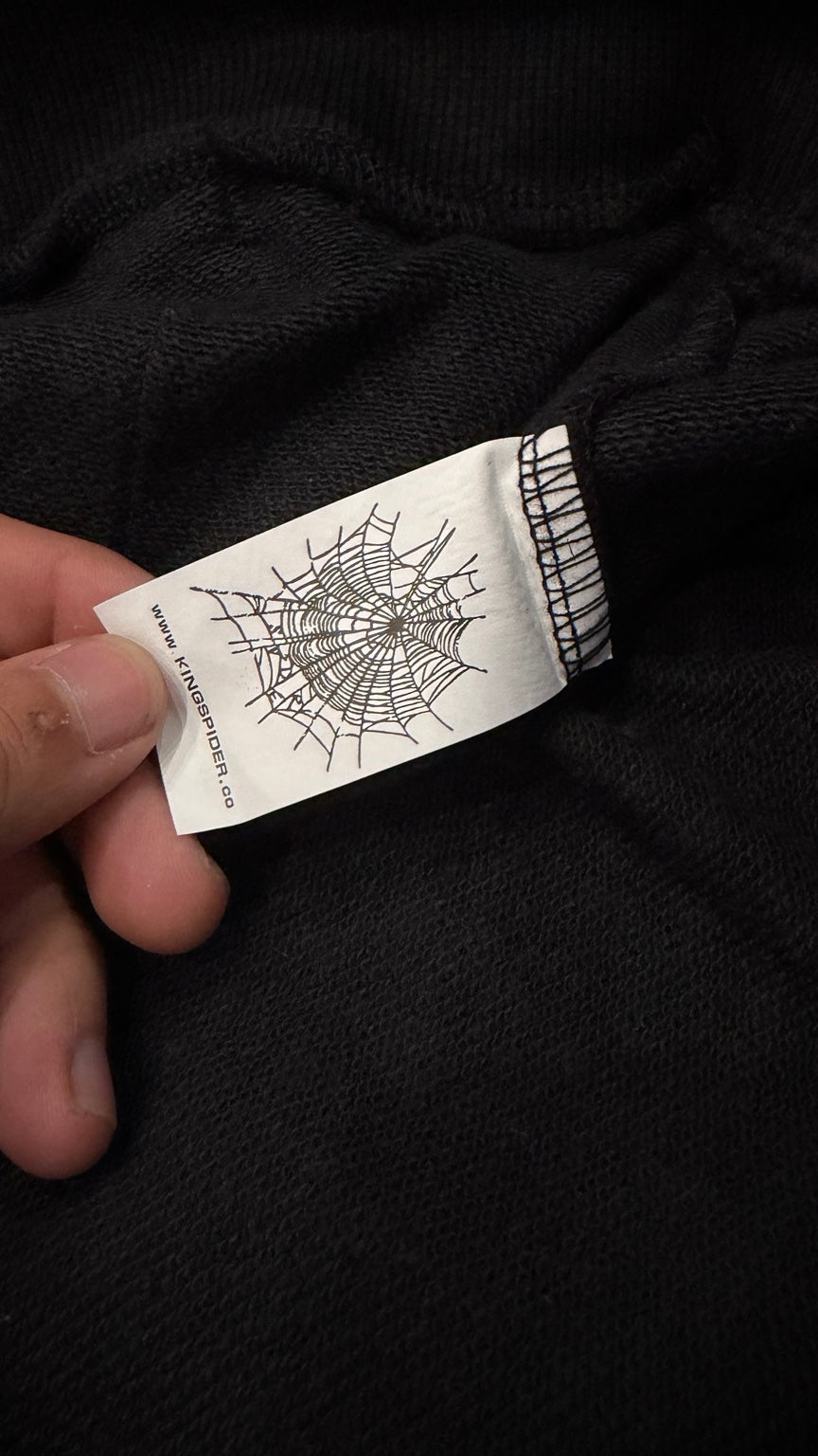 Inside neck label of black rhinestone hoodie