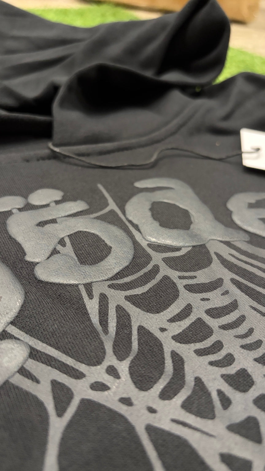 Tonal charcoal raised web print and lettering close-up