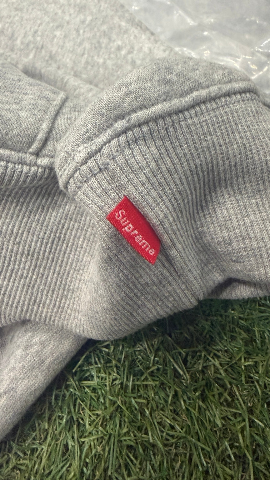 Small red woven logo label at the sleeve cuff